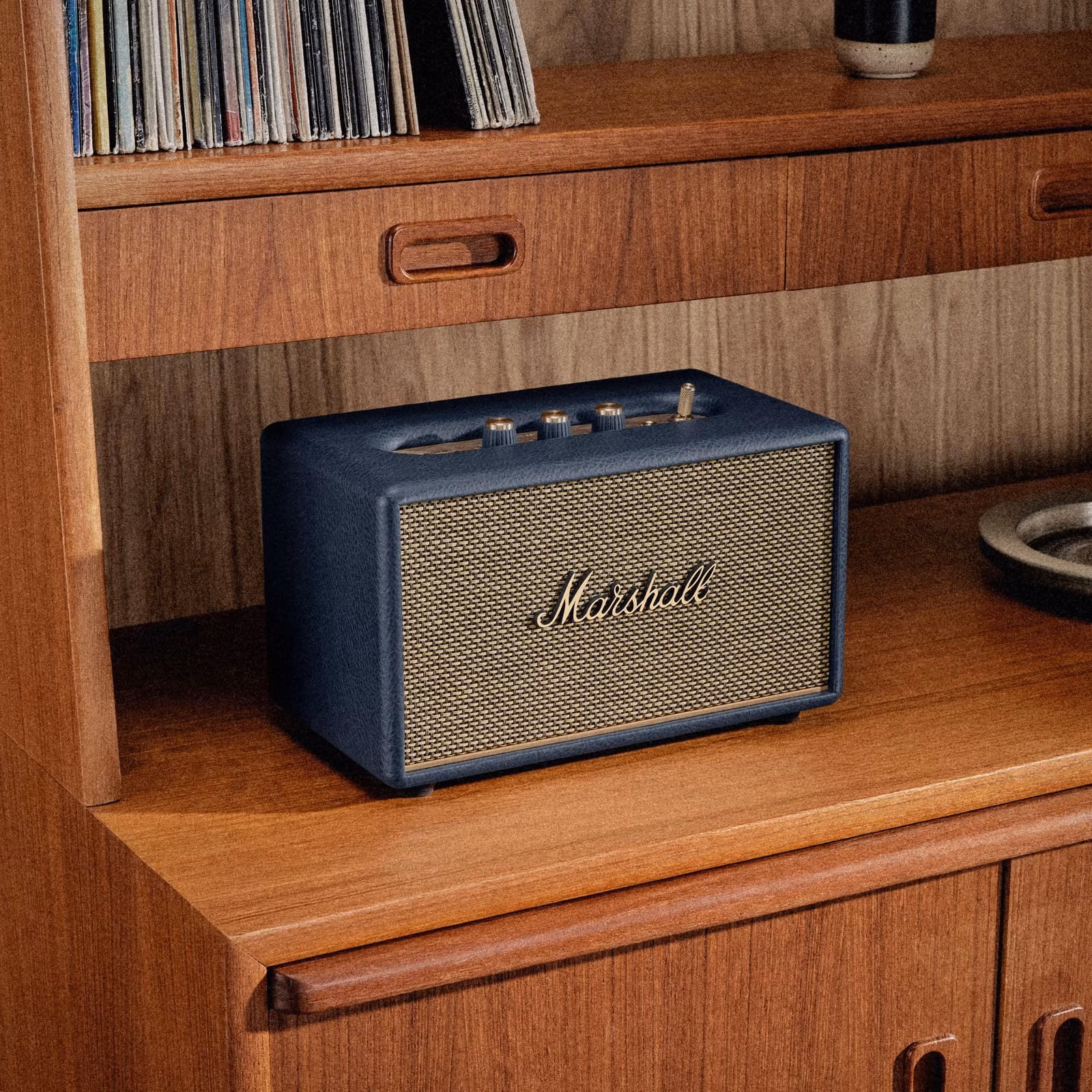 Акустична колонка Marshall Acton III Midnight Blue поруч із вініловими платівками