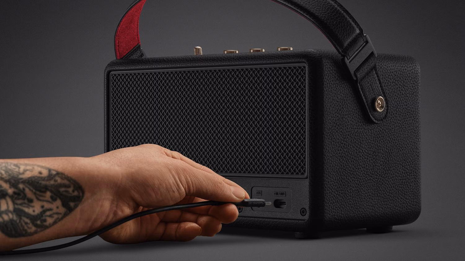 Задня панель Marshall Kilburn III, рука підключає кабель USB-C