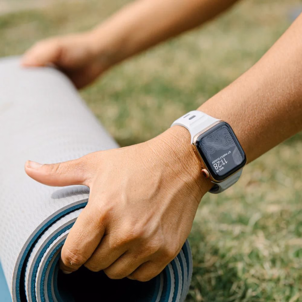 Ремінець Nomad Sport Band у кольорі Lunar Gray для Apple Watch 46mm/49mm поруч із килимком для тренувань