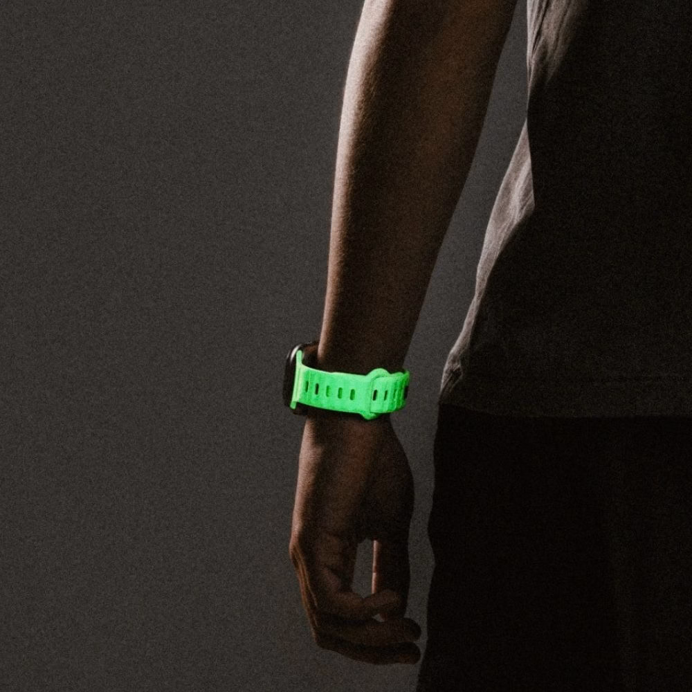 Чоловіча рука з Apple Watch Ultra на ремінці Nomad Glow 2.0, що світиться, демонстрація спортивного дизайну та надійної застібки pin-and-tuck