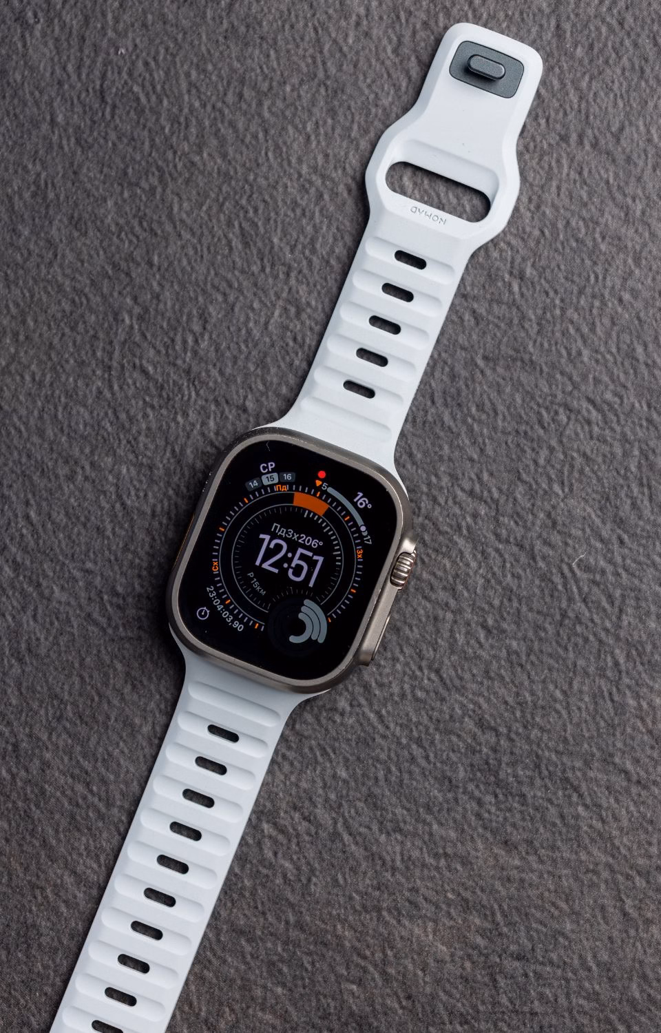 Світло-блакитний ремінець Nomad Sport Band Icy Blue Glow для Apple Watch Ultra 2 на фоні спортивного одягу, преміальний FKM фтореластомір