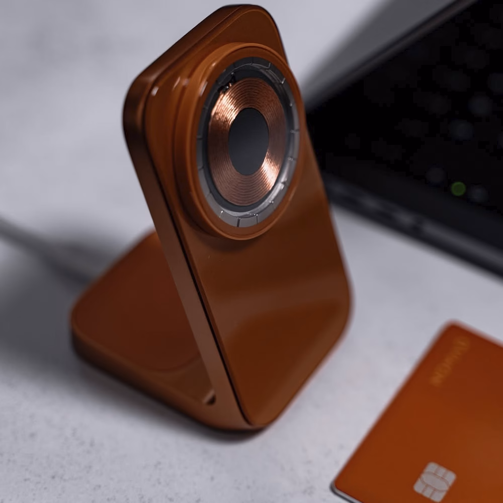 Nomad Stand One Stellar Orange на столі з MacBook та карткою-трекером