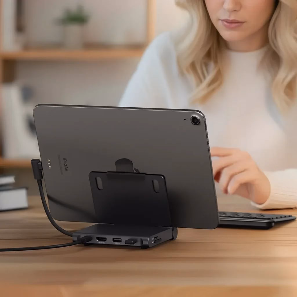 Жінка працює на iPad за столом у кабінеті, вигляд ззаду