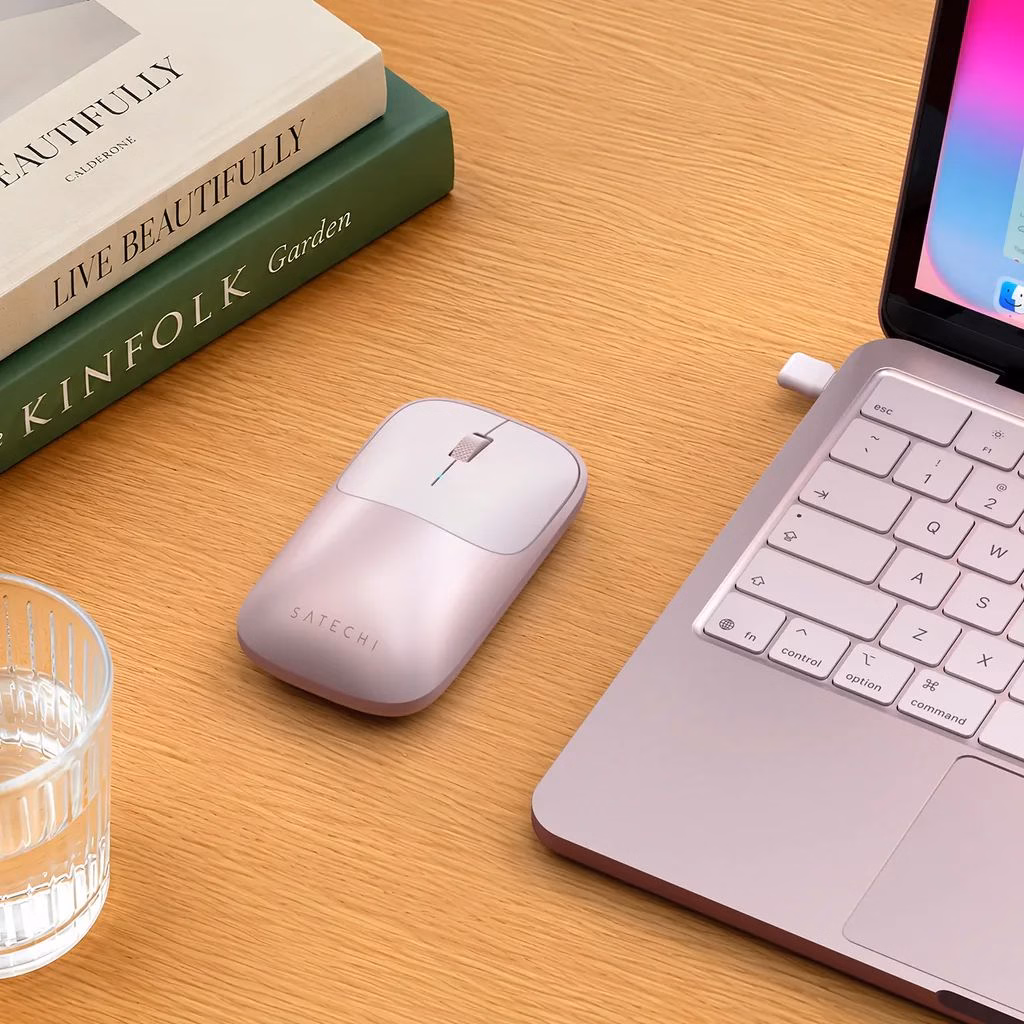 Плоская беспроводная мышь Satechi Slim EX Blush рядом с MacBook
