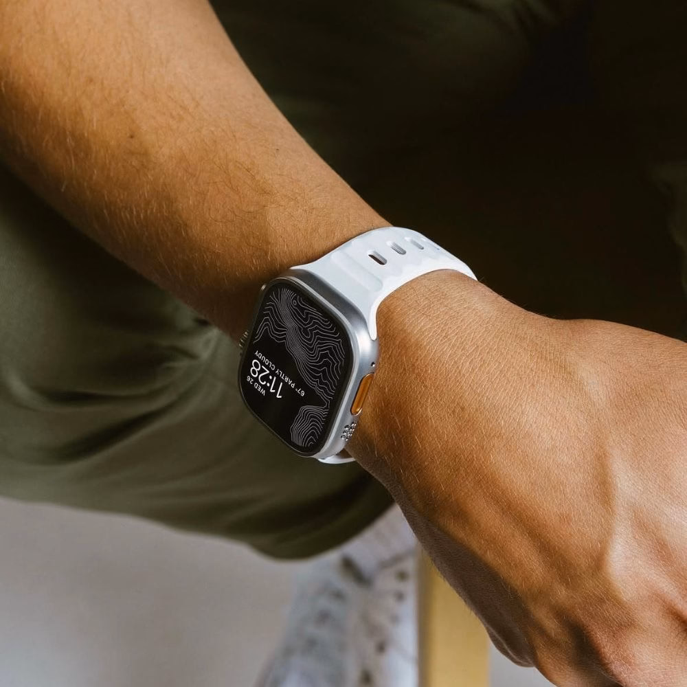 Білий ремінець для Apple Watch Ultra 2 на руці користувача, текстурований дизайн з перфорацією