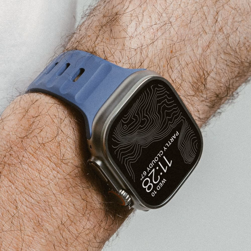 Макро фото ремінця Nomad Sport Band Naval Blue для Apple Watch Ultra, демонстрація водовідштовхувальної текстури та вентиляційних отворів для спорту