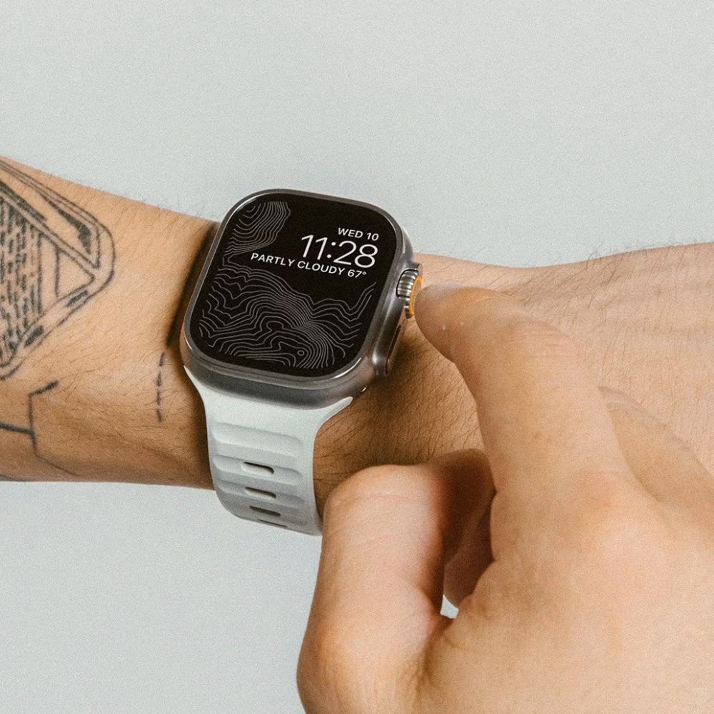 Apple Watch Ultra з білим спортивним ремінцем Nomad Sport Band, акцент на зручності та взаємодії з екраном годинника