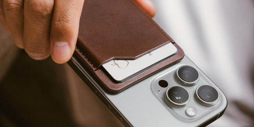 Гаманець Nomad Leather Mag Wallet Camino Brown крупним планом на смартфоні в руці